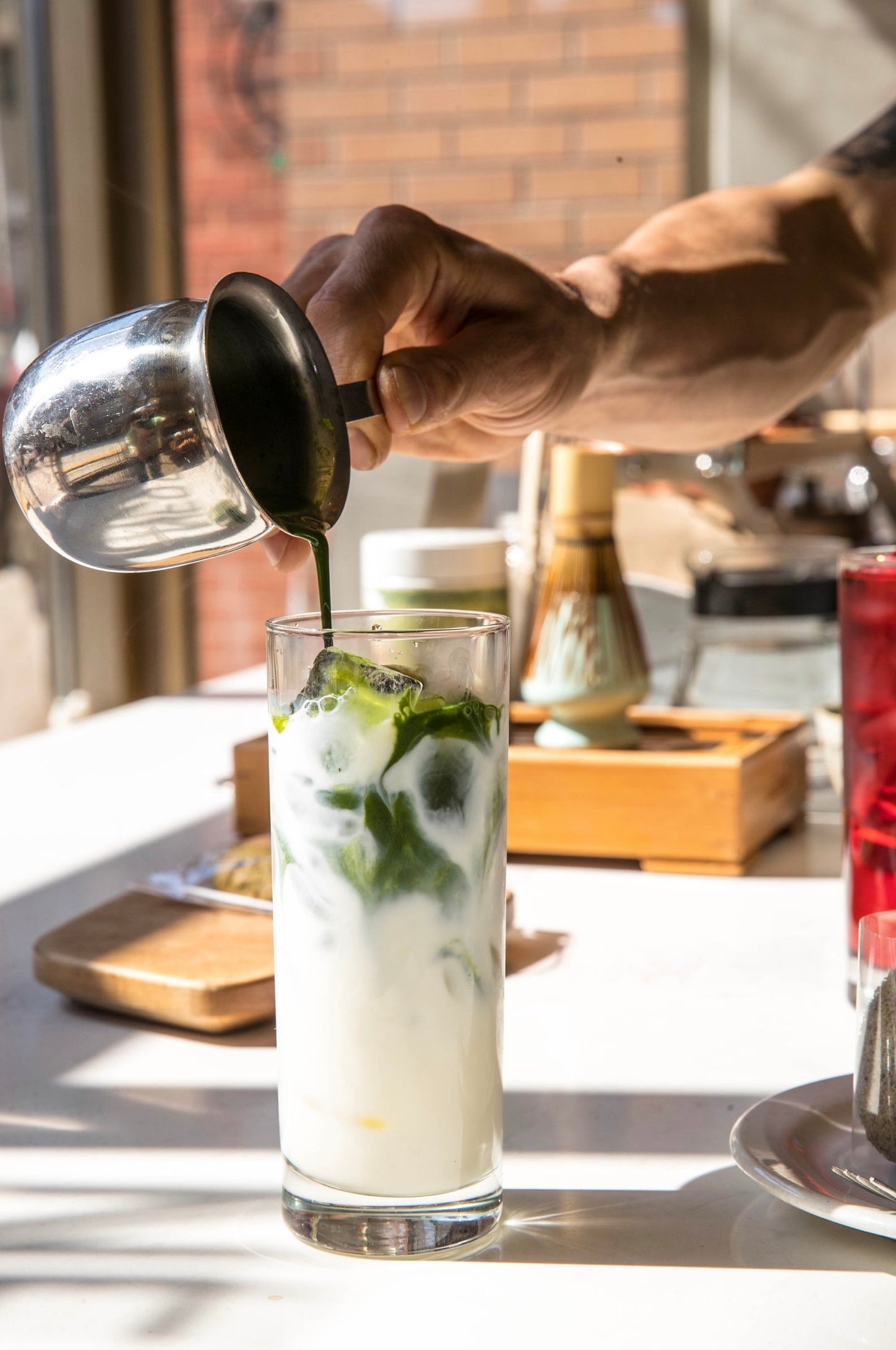 Préparation d'un iced matcha latte par un barista du Coffee Shop Café GUS.